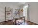 Bright home office space with desk, chair, and shelving with hardwood floors and large window at 1238 Aggie Ln, Indianapolis, IN 46260