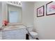 Cozy powder room with floral artwork and modern fixtures including tile floor at 1238 Aggie Ln, Indianapolis, IN 46260