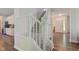 Bright staircase leading to the second level with white wood railing and hardwood floors at 1238 Aggie Ln, Indianapolis, IN 46260