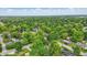Lush, green neighborhood of well-spaced homes with mature trees and manicured lawns seen from an aerial perspective at 1245 Kessler Blvd E Dr, Indianapolis, IN 46220