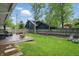 Spacious backyard with a wooden deck, lush green lawn, mature trees, and a privacy fence at 1245 Kessler Blvd E Dr, Indianapolis, IN 46220
