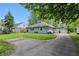 Exterior shot showcasing the house and long driveway leading to a detached two-car garage at 1245 Kessler Blvd E Dr, Indianapolis, IN 46220
