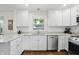 Beautiful, updated kitchen with white cabinetry, stainless appliances, granite countertops and hardwood floors at 1245 Kessler Blvd E Dr, Indianapolis, IN 46220