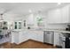 Updated kitchen features stainless appliances, white cabinetry, granite counters, and hardwood floors at 1245 Kessler Blvd E Dr, Indianapolis, IN 46220