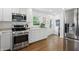 Updated kitchen features stainless steel appliances, white cabinets, granite counters, and hardwood floors at 1245 Kessler Blvd E Dr, Indianapolis, IN 46220