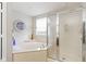 A bright bathroom featuring a luxurious soaking tub, separate shower, and elegant finishes at 13234 Amundson Dr, Carmel, IN 46074