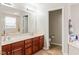 Bathroom with dual vanity, wood cabinets, soaking tub and doorway to separate toilet at 13234 Amundson Dr, Carmel, IN 46074