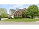 Attractive brick and siding home featuring a lush front lawn and mature trees enhancing its curb appeal at 13234 Amundson Dr, Carmel, IN 46074