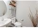 Cozy powder room featuring a modern sink, toilet, and decorative shelves with plush towels at 13234 Amundson Dr, Carmel, IN 46074