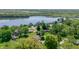 An aerial view shows homes along a lake, surrounded by mature trees and well-maintained lawns at 1328 Toner Dr, Anderson, IN 46012
