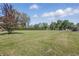 Large backyard with expansive lawn and mature trees at 1328 Toner Dr, Anderson, IN 46012