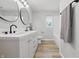 Elegant bathroom with double sinks, modern fixtures, and stylish round mirrors at 1328 Toner Dr, Anderson, IN 46012