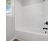 Bright bathroom featuring a clean, tiled shower-tub, white tile and neutral walls at 1328 Toner Dr, Anderson, IN 46012