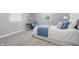 Inviting bedroom with soft carpet, a comfortable bed with blue accents, and natural light from a nearby window at 1328 Toner Dr, Anderson, IN 46012