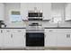 Modern kitchen with stainless steel appliances, stylish white cabinets, dark countertops, and subway tile backsplash at 1328 Toner Dr, Anderson, IN 46012
