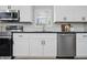 Well-lit kitchen featuring stainless steel appliances, white subway tile backsplash, sleek white cabinets, and dark countertops at 1328 Toner Dr, Anderson, IN 46012
