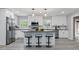 Modern kitchen with white cabinets, stainless steel appliances, an island with bar stool seating, and grey wood-look flooring at 1328 Toner Dr, Anderson, IN 46012