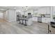 Bright modern kitchen featuring white cabinets, stainless steel appliances, kitchen island with seating, and light grey wood-look flooring at 1328 Toner Dr, Anderson, IN 46012