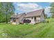 The backyard features a wooden deck with a grill and patio seating, surrounded by lush green grass and trees at 1409 S Northview Dr, Martinsville, IN 46151