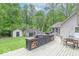 Spacious outdoor deck boasts a built-in grilling area, dining furniture, and wooded views perfect for entertaining at 1409 S Northview Dr, Martinsville, IN 46151