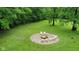 Large lawn featuring a cozy fire pit with yellow chairs nestled amongst the trees at 1409 S Northview Dr, Martinsville, IN 46151