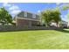 Beautifully maintained backyard with green grass, a retaining wall, and mature trees at 14215 Stacey St, Carmel, IN 46033