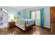 Comfortable bedroom with hardwood floors, light blue walls, and ample natural light from the window at 14215 Stacey St, Carmel, IN 46033