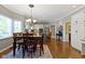 Bright dining room features hardwood floors, decorative chandelier, and flows into kitchen at 14215 Stacey St, Carmel, IN 46033