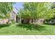 Charming brick home featuring a lush green lawn, mature trees, and a welcoming front entrance at 14215 Stacey St, Carmel, IN 46033