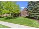 Lovely brick house surrounded by mature trees and a manicured lawn creating a welcoming curb appeal at 14215 Stacey St, Carmel, IN 46033