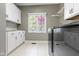 Bright laundry room features modern washer/dryer and white cabinets with granite countertops at 14215 Stacey St, Carmel, IN 46033