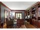 Executive office with hardwood floors, wood trim, custom bookshelves, and ample natural light at 14215 Stacey St, Carmel, IN 46033
