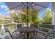 Outdoor patio featuring a wrought iron table, four chairs, and an umbrella for sun protection at 14215 Stacey St, Carmel, IN 46033