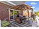 Enjoy outdoor dining on this back patio with a round table, umbrella and brick exterior at 14215 Stacey St, Carmel, IN 46033