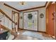 Bright foyer featuring hardwood floors, a staircase, and a white front door with glass inserts and floral wreath at 14809 Senator Way, Carmel, IN 46032