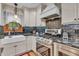 Close-up of kitchen featuring a stainless steel range, apron sink, and black backsplash at 14809 Senator Way, Carmel, IN 46032