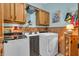 Well-organized laundry room with wood paneling, washer, dryer, and upper cabinets at 14809 Senator Way, Carmel, IN 46032