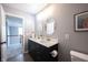 Bright bathroom featuring a dual sink vanity with black cabinets and modern, round mirrors at 16579 Lakeville Xing, Westfield, IN 46074