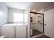Bright bathroom includes laundry and a tiled shower with a glass enclosure at 16579 Lakeville Xing, Westfield, IN 46074
