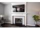 Close-up of a fireplace with white mantel, decorative tile surround, and mounted television above at 16579 Lakeville Xing, Westfield, IN 46074