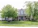 Charming two-story home showcasing professional landscaping, a brick facade, and a welcoming front porch at 16579 Lakeville Xing, Westfield, IN 46074