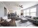 Open-concept living space with gray sectional sofa, kitchen bar, and dining area with ample natural light at 16579 Lakeville Xing, Westfield, IN 46074