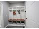 Beautiful mudroom with white cubbies, dark wooden benches, and white door at 16579 Lakeville Xing, Westfield, IN 46074