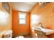 Small bathroom with a toilet, sink, and a window at 2114 Sugar Grove Ave, Indianapolis, IN 46202