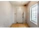 A view of the entryway, with a door, a window, and peeling paint on the walls at 2114 Sugar Grove Ave, Indianapolis, IN 46202