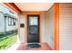 Inviting entryway features orange trim, a secure black door, and charming decorative accents at 2114 Sugar Grove Ave, Indianapolis, IN 46202