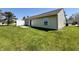 Grassy backyard with a small patio area, a white fence and vinyl siding at 212 Woodberry Dr, Danville, IN 46122