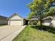 Pleasant single-story home featuring a lush green lawn and a large shade tree at 212 Woodberry Dr, Danville, IN 46122