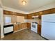 Functional kitchen features wood cabinets, white appliances, and tile flooring at 212 Woodberry Dr, Danville, IN 46122