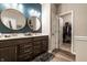 This bathroom features a double vanity, sleek lighting, walk in closet, and round decorative mirrors at 2675 Cottage Ct, Brownsburg, IN 46112